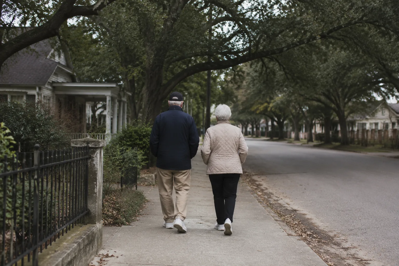 A patient walking a tree-lined path in overcast light